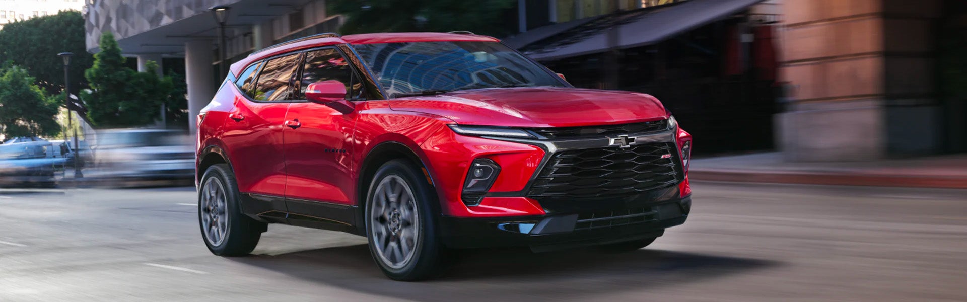 Red 2023 Chevy Blazer RS driving down an open road.