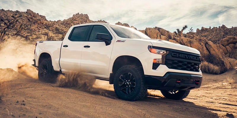 a white 2024 Chevy Silverado 1500 from the rear at an angle.