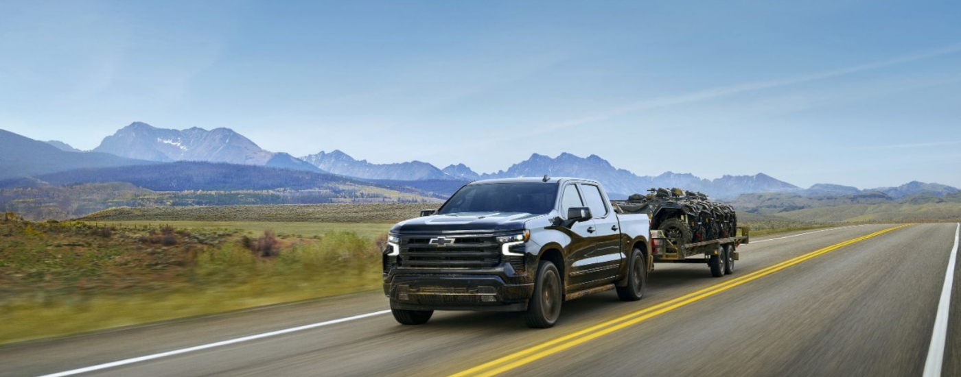 Black 2025 Chevy Silverado 2500 HD towing ATV's