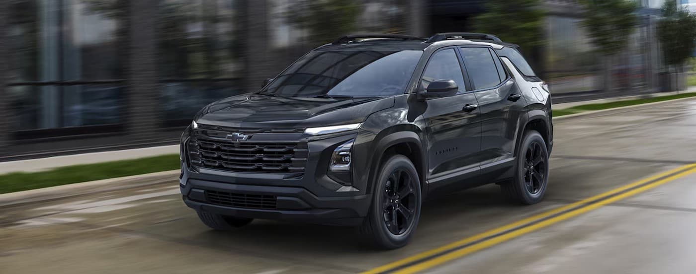 A black 2026 Chevy Equinox for sale driving in a city.